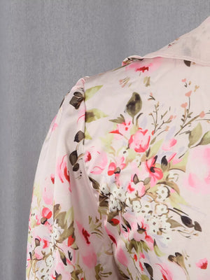 Charming ruffled floral mini dress in light pink with a buttoned collar and puff sleeves.