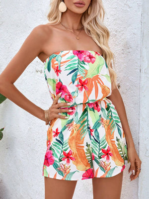 Strapless romper with a white background and a colorful tropical floral and leaf print.