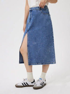 Medium wash denim midi skirt with a high slit, cotton fabric, and a casual style.