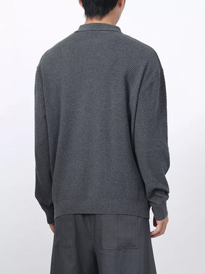 Men's dark gray textured knit polo with long sleeves and a classic collar.