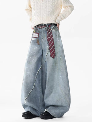 Oversized light wash denim jeans with pearl accents, paint splatters, and a tie detail.