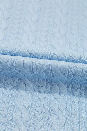 Light blue cable knit loungewear set fabric detail with textured chevron pattern.