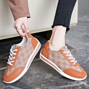 Lace-up round toe sneakers in tan with brown logo pattern and tan leather accents.