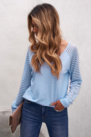 Light blue raglan sleeve top with sheer stripe detail on sleeves.