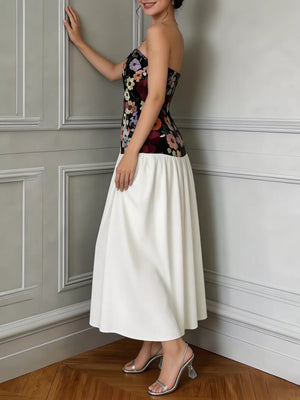 Strapless maxi dress with floral embroidered bodice and white skirt.