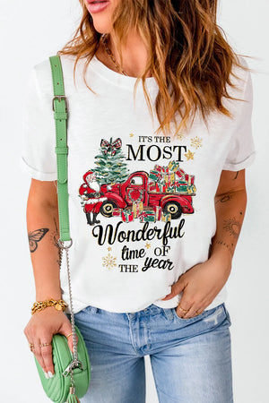White graphic tee with Christmas truck, tree, Santa, and presents.