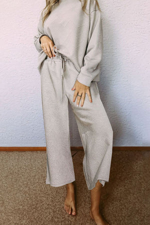 Beige loungewear set with drop sleeves and wide-leg pants, featuring a geometric pattern.