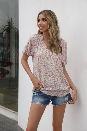 Blush pink floral ruffle yoke cap sleeve blouse with a V-neck.