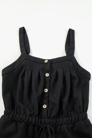 Black waffle knit jumpsuit with button front, drawstring waist and wide legs.