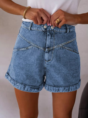 Blue denim shorts with high waist, angular seams, button fly, and cuffed hem