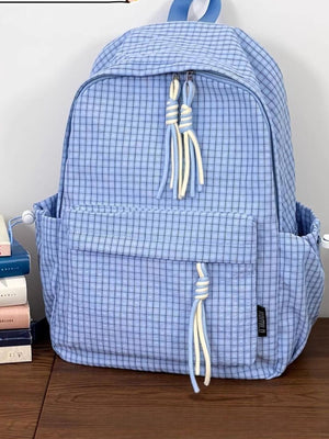 Blue plaid nylon backpack with tassel zipper pulls and side pockets.