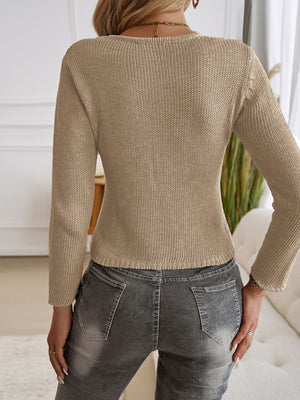 Tan knit cropped cardigan with long sleeves and a ribbed hem, shown from the back.