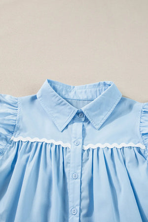 Light blue poplin blouse with ruffled yoke and white scalloped trim detail.