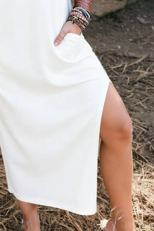White cotton midi dress with pockets and side slit.