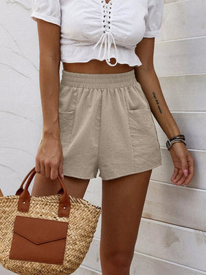 Beige elastic waist shorts with pockets, casual loungewear for women.