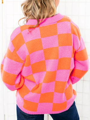 Checkerboard button-up sweater in strawberry pink and orange with a collared neckline.