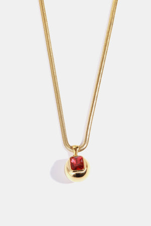 Gold necklace with orb pendant and deep red square stone