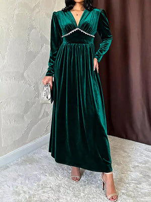 Green velvet maxi dress with V-neck, ruched bodice detail, and long sleeves.
