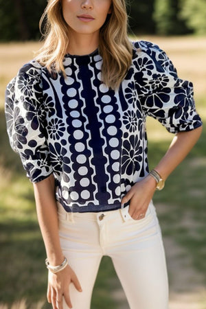 Black floral puff sleeve blouse with button back and high neckline.