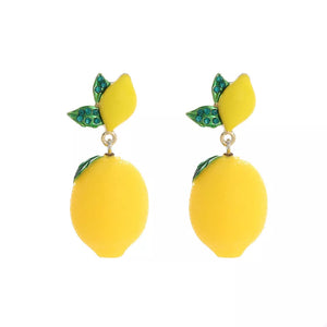 Gold-plated drop earrings with yellow lemon charms and green leaf details.