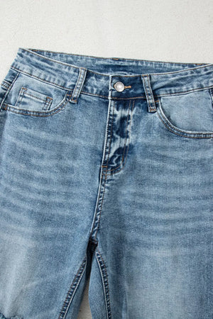 Distressed light wash denim flare jeans with open knees and cropped length.