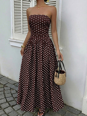 Brown polka dot A-line maxi dress with strapless neckline and cinched waist.