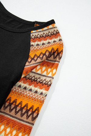 Black raglan tee with orange, brown, and cream Aztec patterned sleeves.