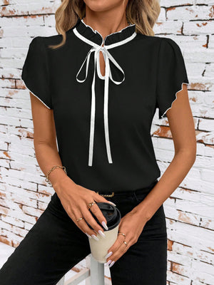 Black maternity blouse with frilled tie-neck and white trim, short sleeves.
