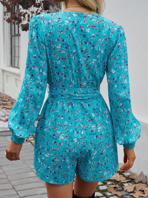 Floral wrap romper in pastel blue with blouson sleeves and a tie waist