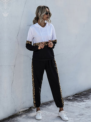 White and black colorblock loungewear set with leopard trim on sleeves and pants.