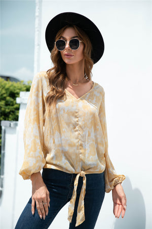 Light yellow swirl print blouson top with tie-front and balloon sleeves.