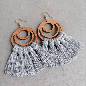 Light gray macrame tassel earrings with wood circle detail.