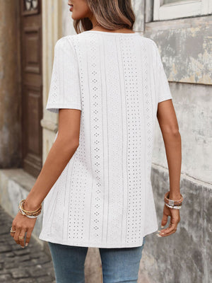 White eyelet blouse with square neck and puff sleeves, detailed with decorative cutouts.