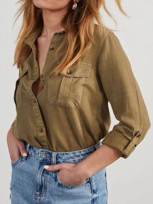Olive brown washed denim utility shirt with buttoned chest pockets and rolled sleeves.