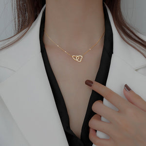 Gold interlocking heart pendant necklace with delicate chain.