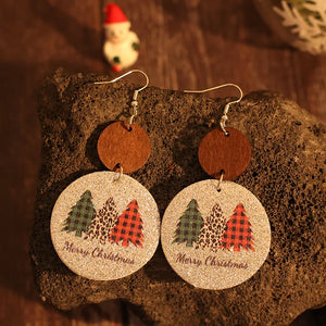 Festive drop earrings with Christmas trees and Merry Christmas text on a glittery green background.