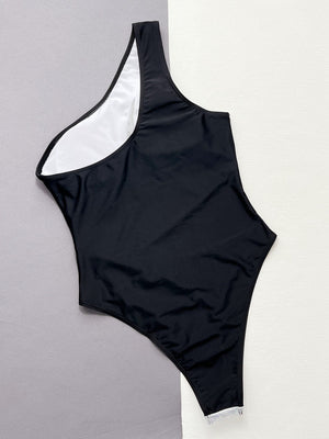 Black one-shoulder swimsuit with white lining and sequin panel detail.