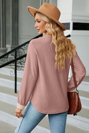 Pink textured V-neck blouse with embroidered cuff detail
