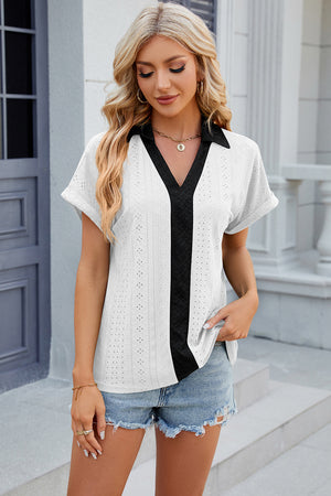 White perforated polo top with black contrast panel and collar.