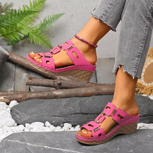 Pink open-toe wedge sandals with decorative gold accents and a comfortable contoured sole.