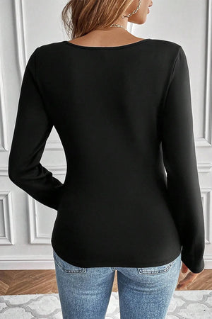 Black long sleeve thermal top with scoop neckline, styled with jeans.