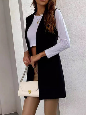 Black draped lapel vest with asymmetric hemline worn over a white top.