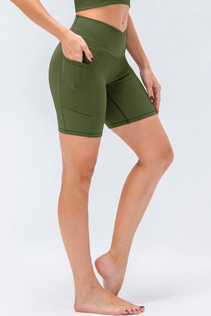 Cross-waist bike shorts in Matcha Green with side pockets and a textured ribbed fabric.