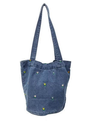 Denim tote bag with whimsical floral embroidery and dual shoulder straps.