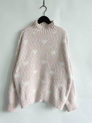Blush pink acrylic turtleneck sweater with a subtle heart motif pattern.