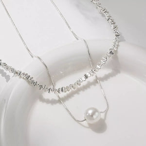 Elegant double layered silver necklace with pearl accent and textured beads