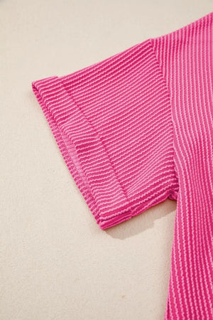 Pink ribbed maternity t-shirt with striped pattern and short sleeves.