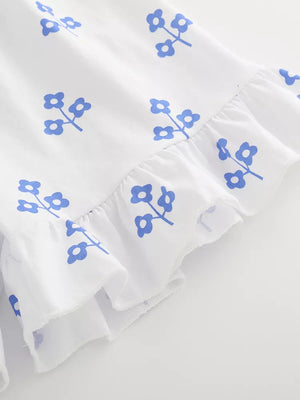 White cotton toddler set with blue floral print and ruffled hem.