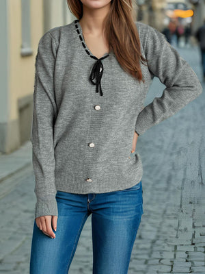 Gray knit cardigan with ribbon trim neckline, tie, and button front.