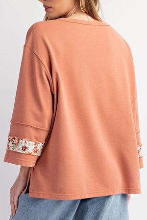 Sherbet sweatshirt with floral appliqué raglan sleeves and raw edge details.